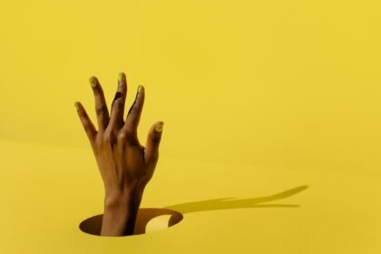 persons hand on yellow surface