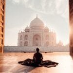 person sitting in front of the taj mahal