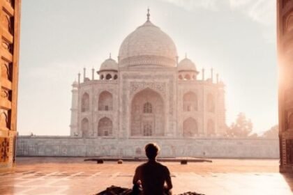 person sitting in front of the taj mahal