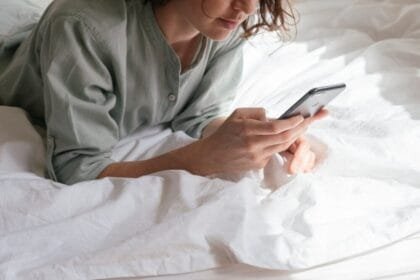 woman using smartphone in bed