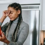 sad young ethnic lady arguing during video call