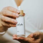 person holding white plastic bottle