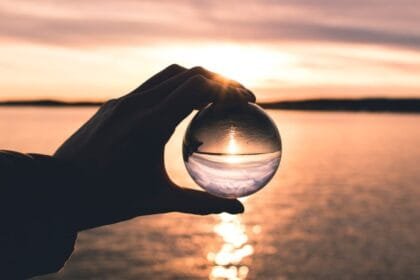 photo displays person holding ball with reflection of horizon