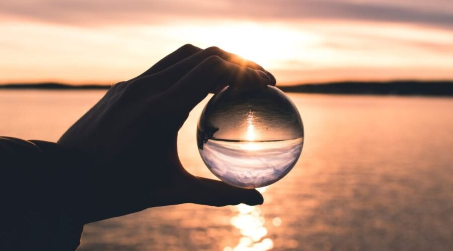 photo displays person holding ball with reflection of horizon