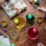 people holding silver spoons with colored eggs