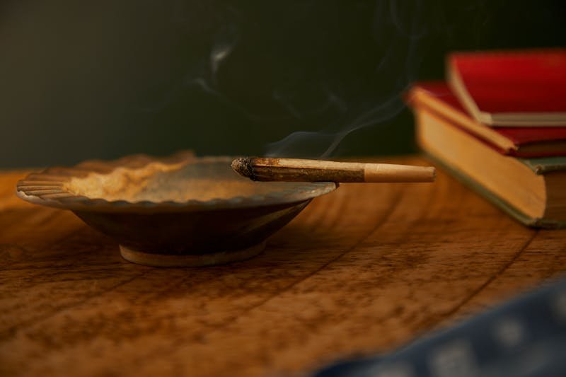 hábito de fumar Burning Rolled Cigar on Metal Ashtray